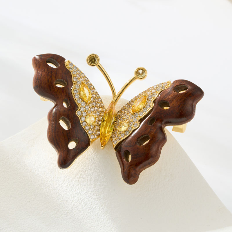 A light luxury retro wooden butterfly brooch made of copper alloy with slightly inlaid zircon, exuding a sense of high-end and exquisite clothing. A new type of brooch and corsage Application Scenario