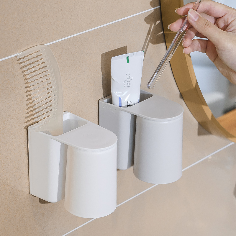 A magnetic toothbrush cup for a family of three is hung upside down at the bottom to drain water. A magnetic mouthwash cup is hung on the wall to brush teeth Application Scenario