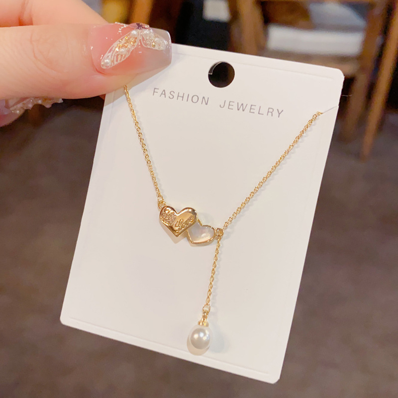 This is a unique, fashionable, sweet and versatile double heart-shaped pearl tassel necklace with a touch of elegance, individuality, and a light luxury design. It's a collarbone chain for women details Picture
