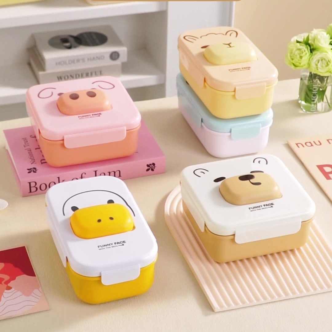 Cute compartments student lunch box that can be heated in a microwave oven. Home cartoon bento box. Office worker lunch box with tableware