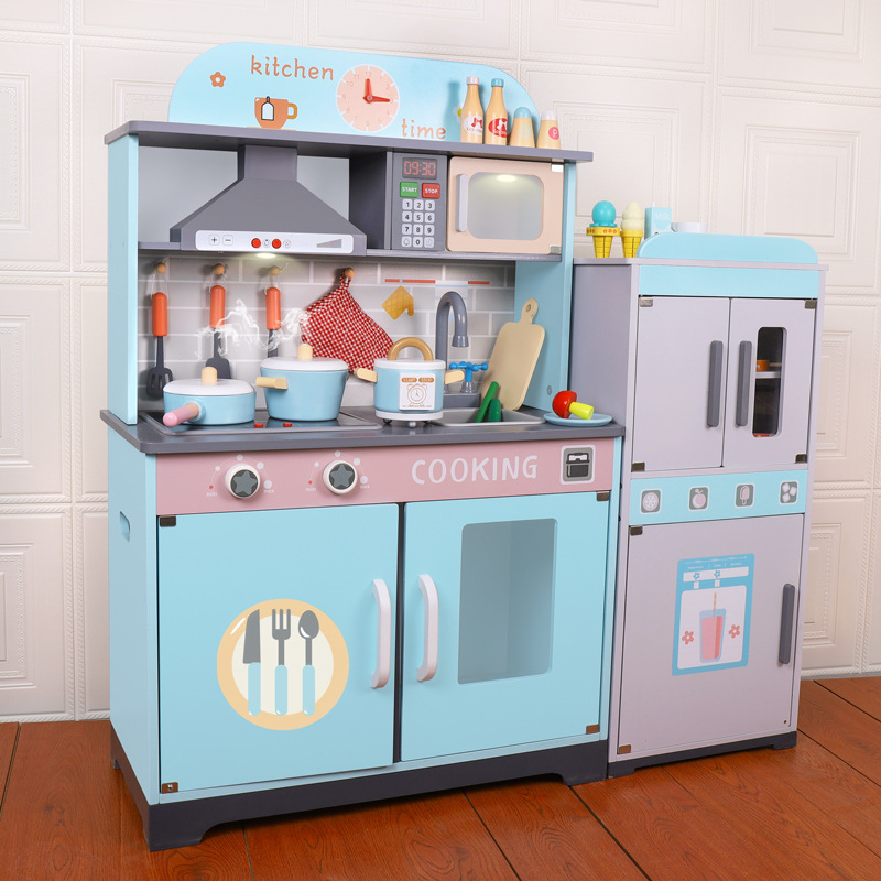 Children's simulated wooden blue kitchen toys. 3-year-old girl plays house in kindergarten with wooden kitchenware and stove scene