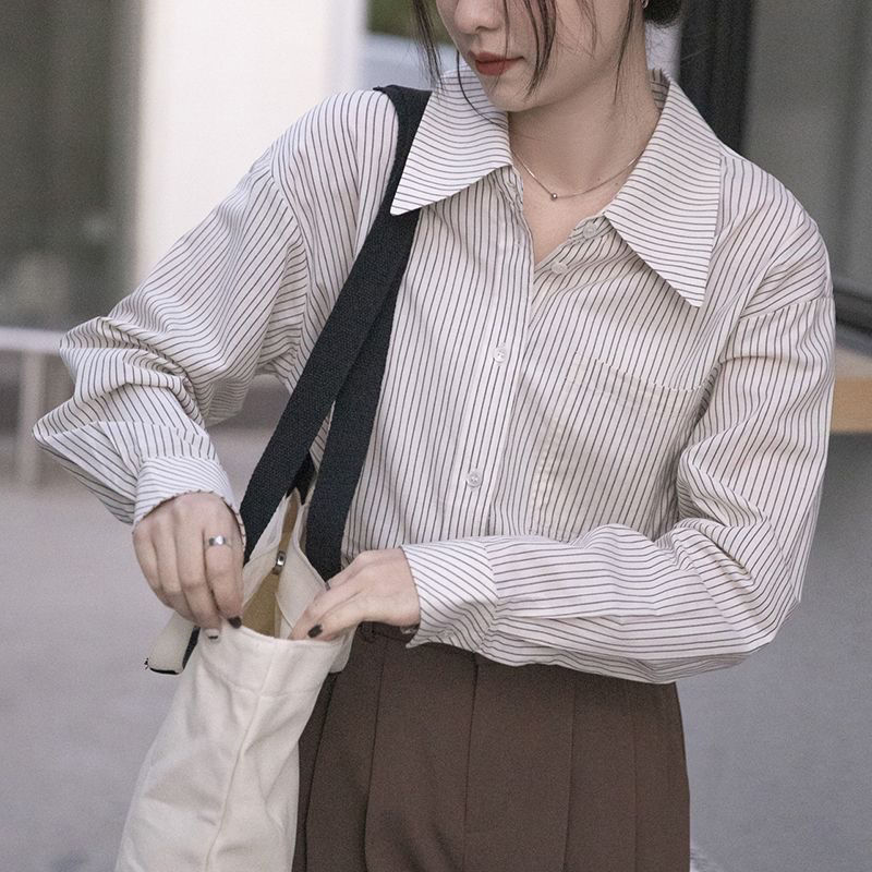 The new design of the blue striped shirt for women in Spring and autumn 2025 is unique, loose and slimming. It is a long-sleeved shirt worn outside in spring and autumn details Picture