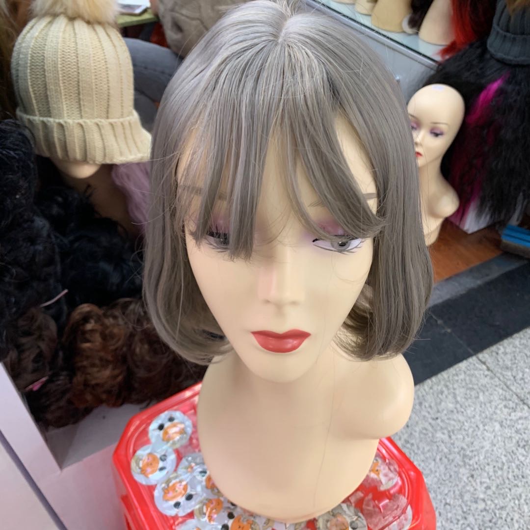 A popular female wig with short hair, air bangs, and a grey figure-eight fringe