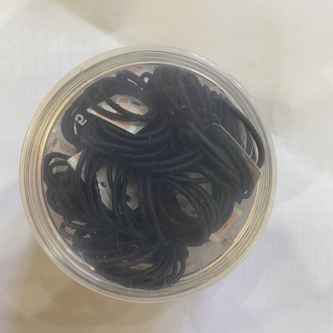 A simple and versatile black nylon headband in a box