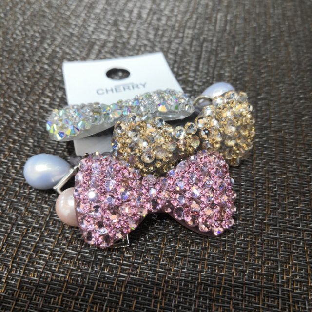 A cute hair clip with a full diamond bow on the back of a Korean girl's head, a ponytail clip and a horizontal clip