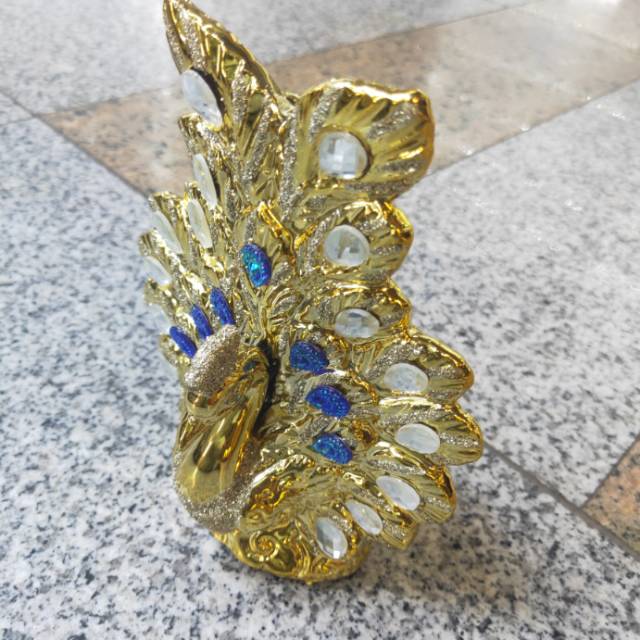 A golden peacock spreading its tail with diamonds details Picture