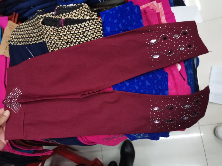 A deep red, diamond-encrusted cotton children's dress with leggings on top