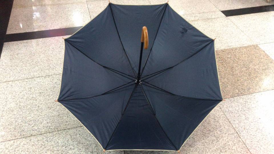 Compact folded umbrella inside cloth bag next to everyday items