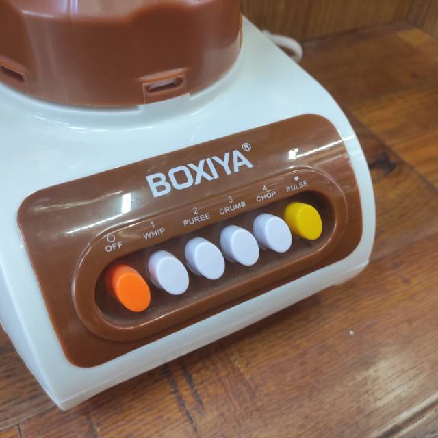 Juicer with colorful fruits and vegetables nearby