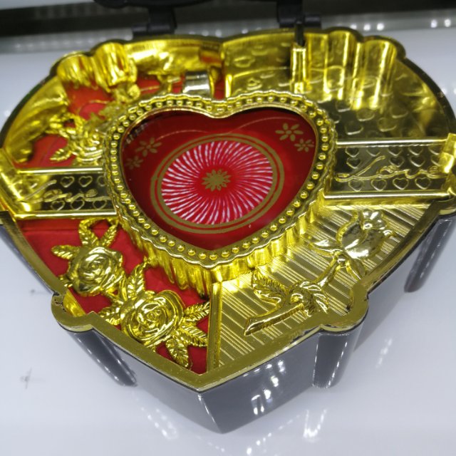 A retro music box in the shape of a heart box, half red and half gold Specification image