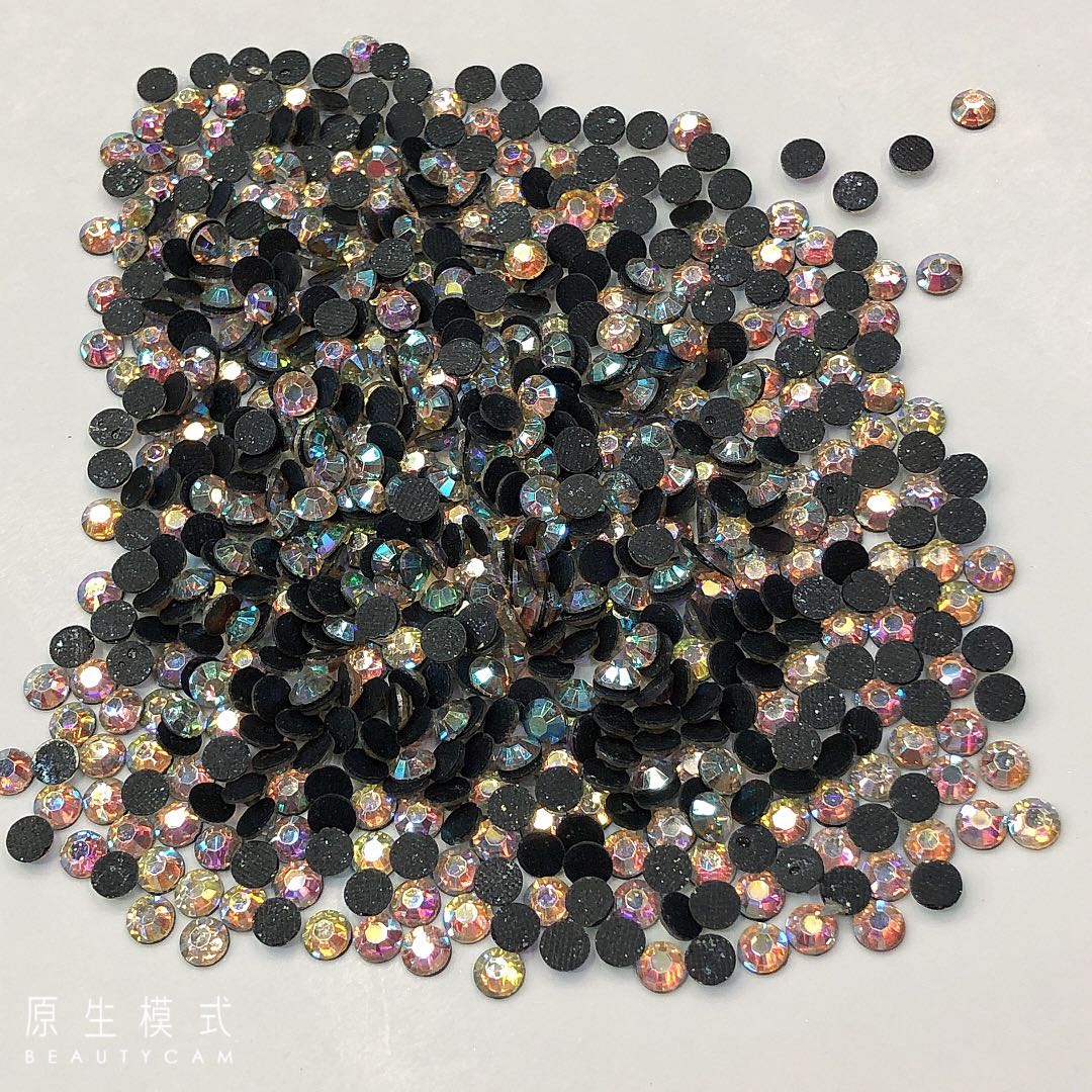 Close-up of white AB resin drills applied to a nail art design under studio lighting