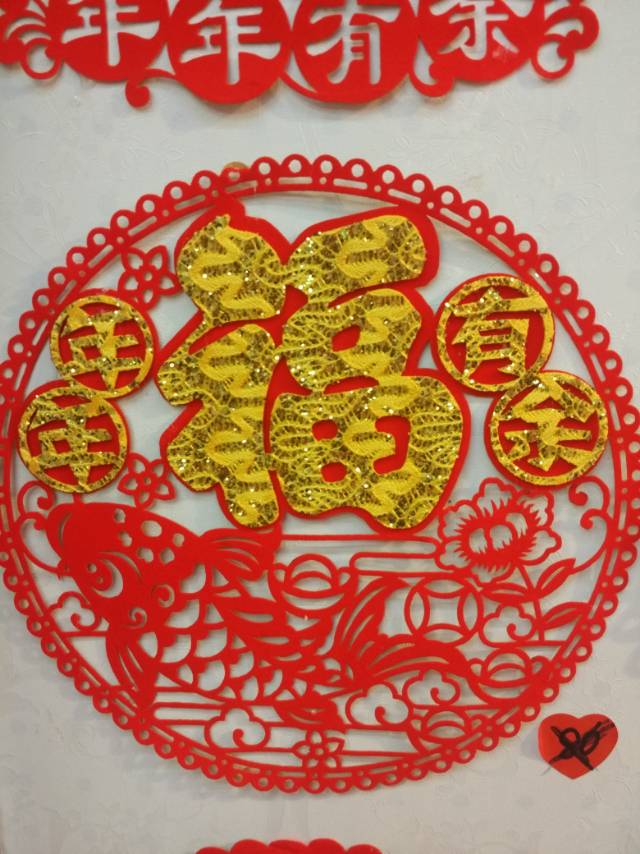 The hollowed-out window flower pendant with the character "Fu" is a festive Spring Festival decorative handicraft