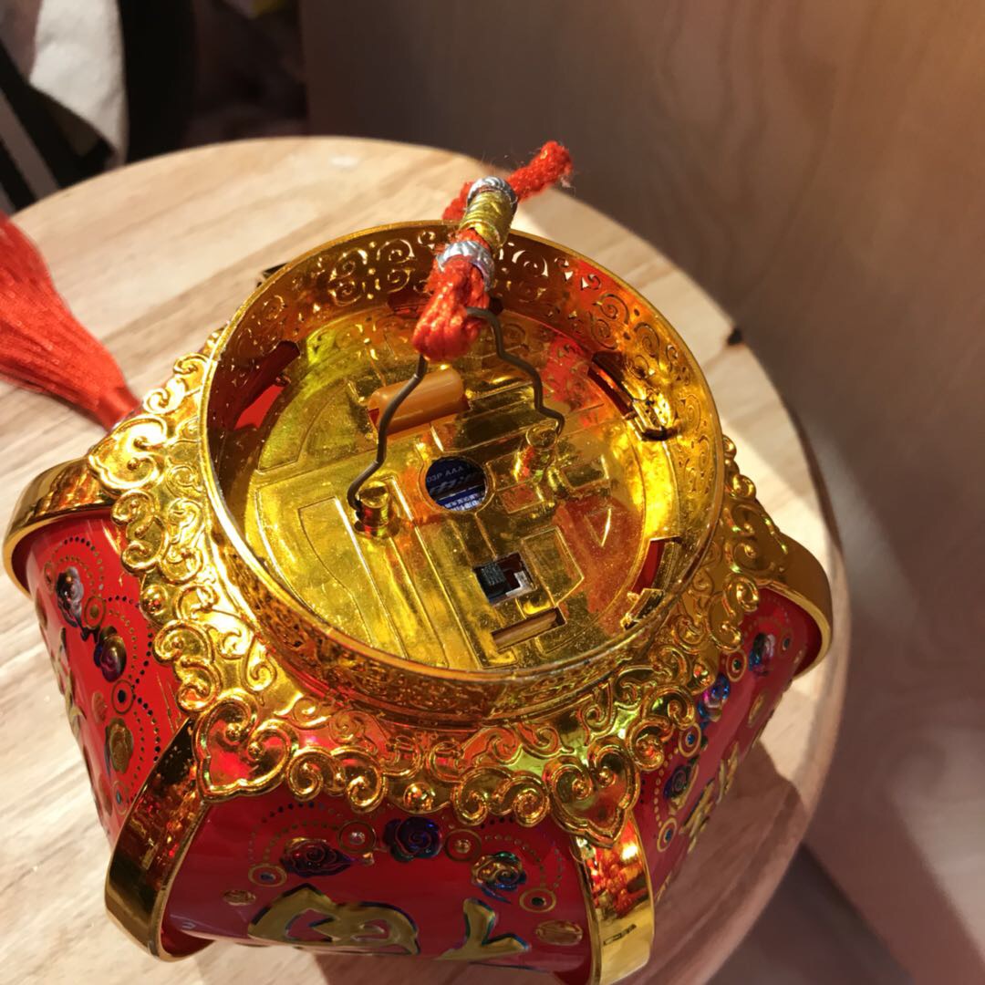The small palace lantern features a golden and red color scheme with the character "Fu" printed on its surface in a Chinese style details Picture