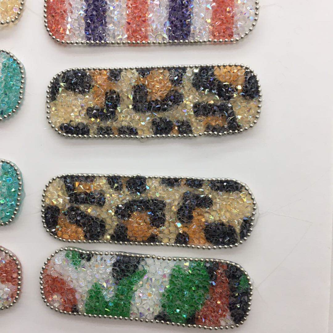Finished handmade hair clips including galaxy-themed braid clips, rainbow-linked hoops, and punk-style studded clouds