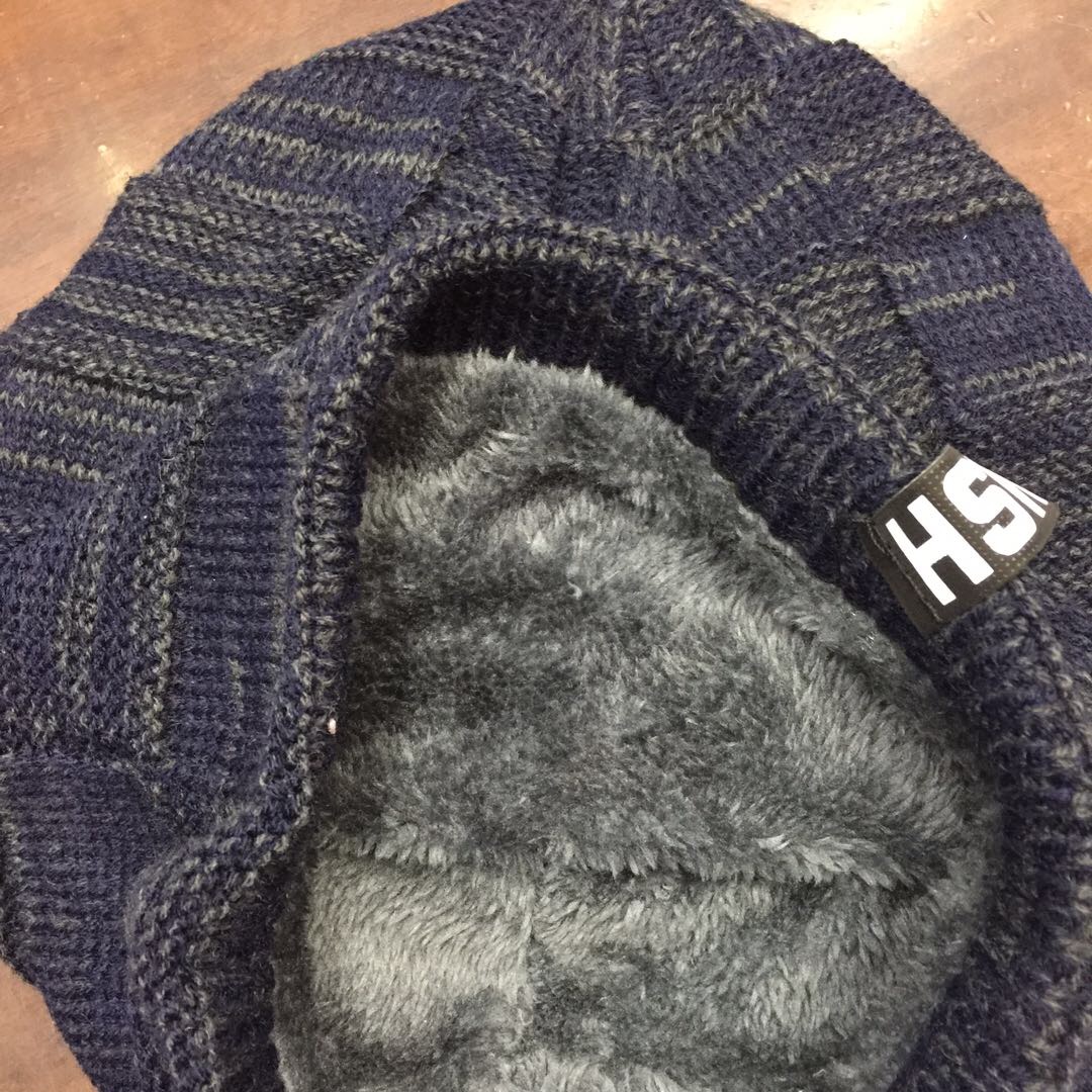 Woman wearing cozy wool beanie walking through autumn park with baby stroller