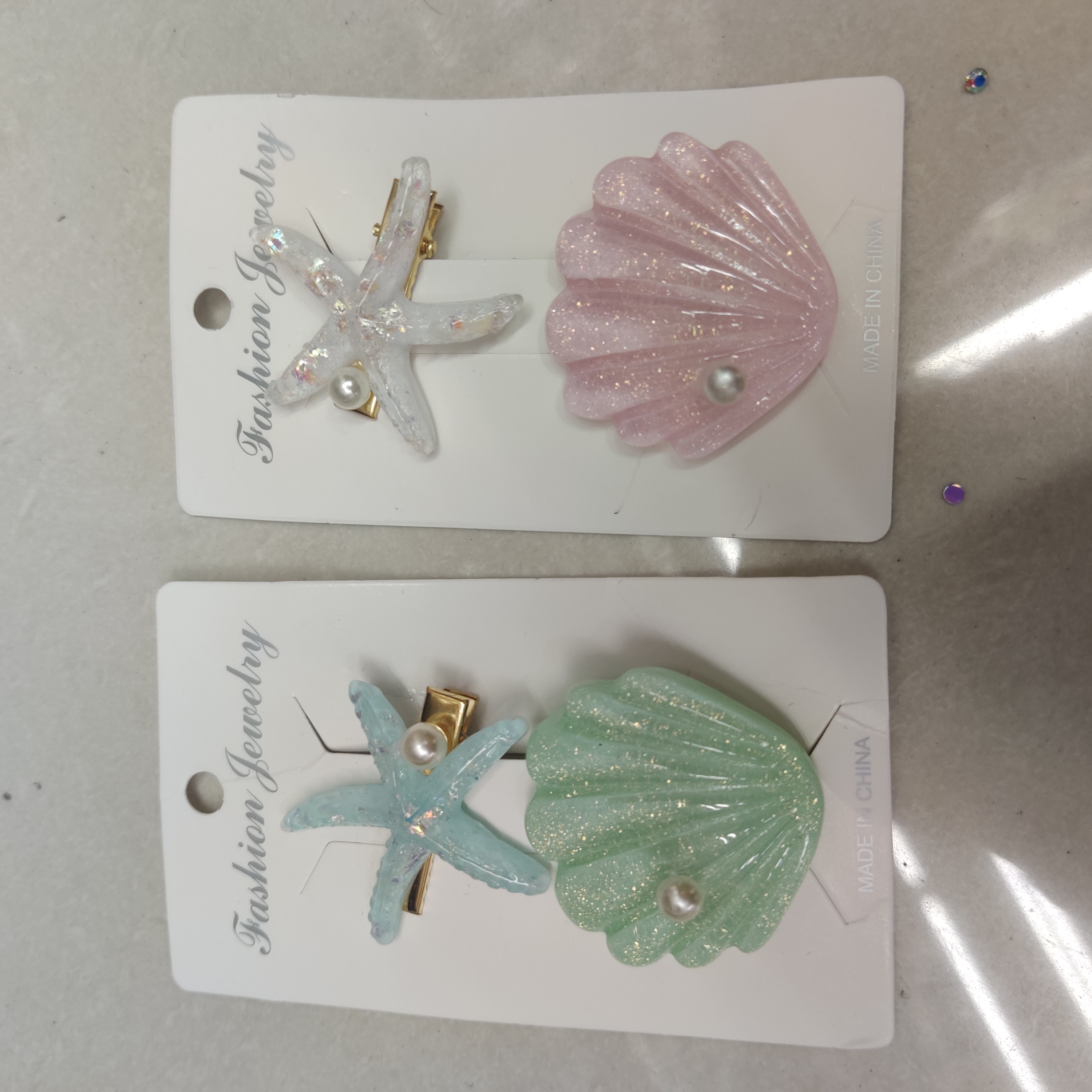 Handheld shot of textured acetate hair clips with pearlescent finish