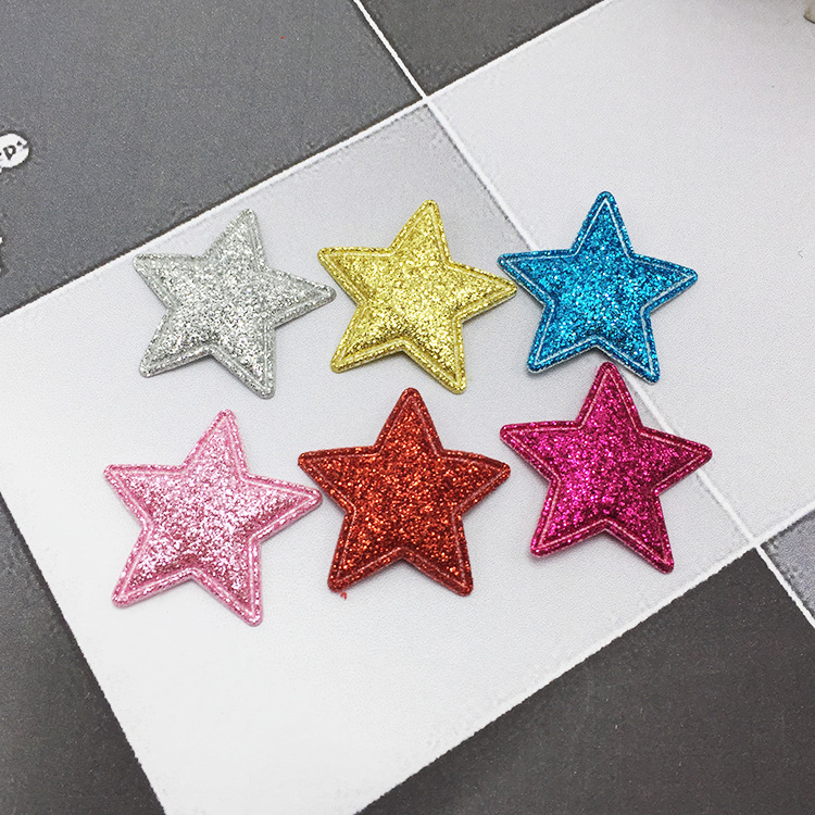 Close-up of gold star hair clips showing texture and shine