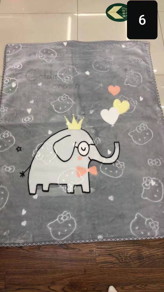 Close-up of cartoon cloud blanket texture showing soft material and embroidered smile