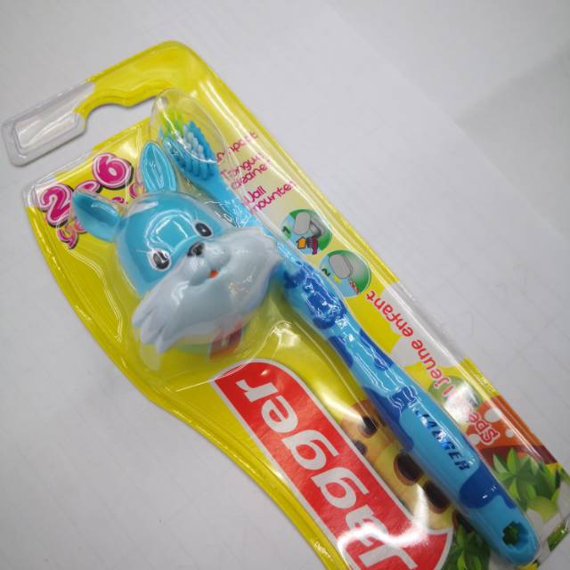 Child holding both cow and rabbit toothbrush with excitement