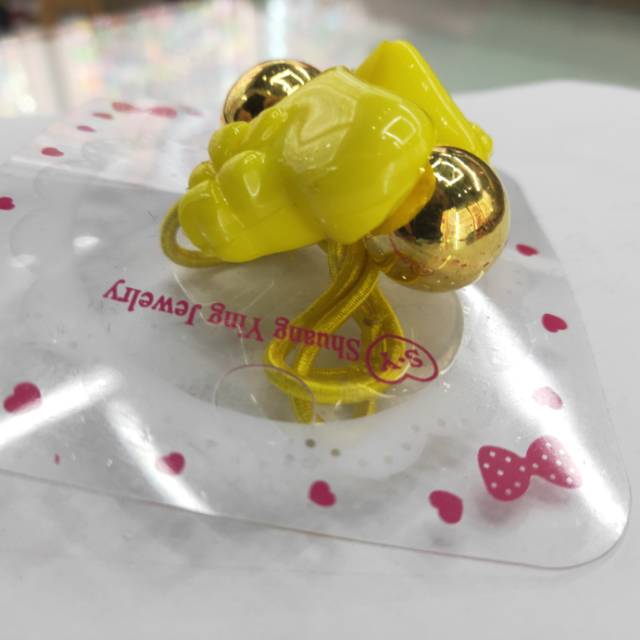 A cute little girl with a yellow heart-shaped hair tie that won't damage her hair and a small hair band details Picture