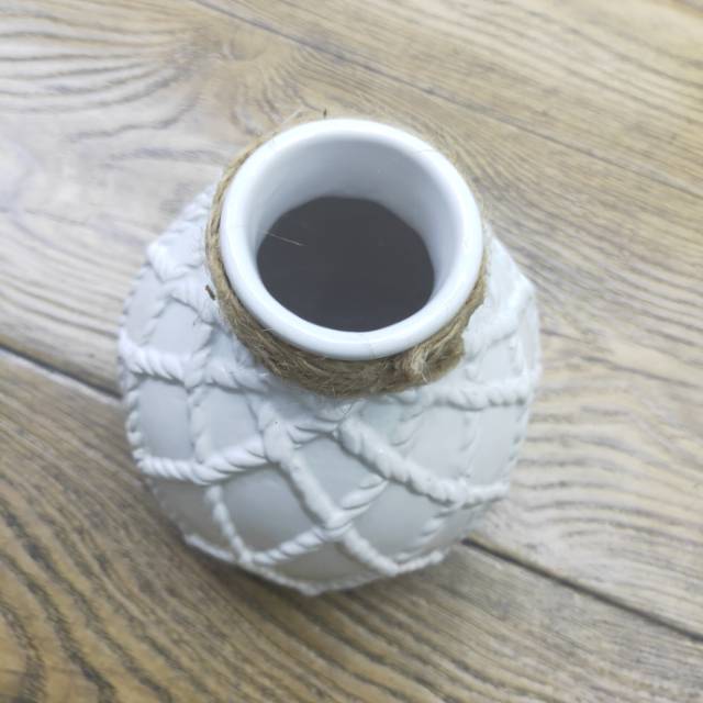 A sample of a white patterned vase with a hemp rope, a hotel living room decoration details Picture