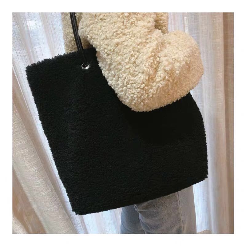 Close-up of faux fur bag showing satin ribbon and textured fabric
