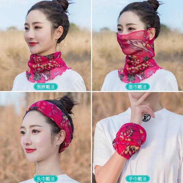 Woman styling silk neck wrap as a headscarf while walking through a tree-lined park in autumn