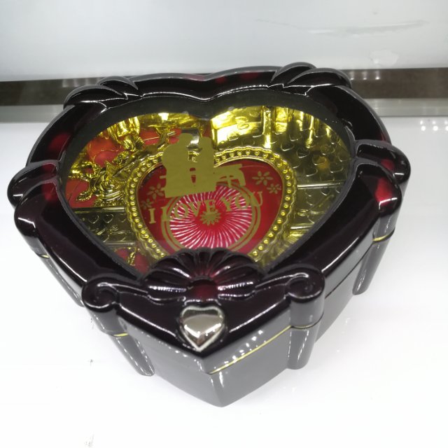 A retro music box in the shape of a heart box, half red and half gold