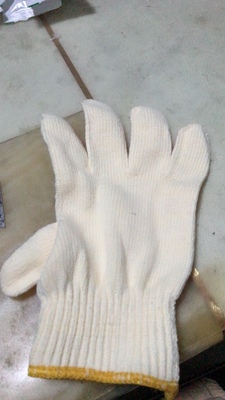 Worker using gloves to handle machinery in an industrial setting