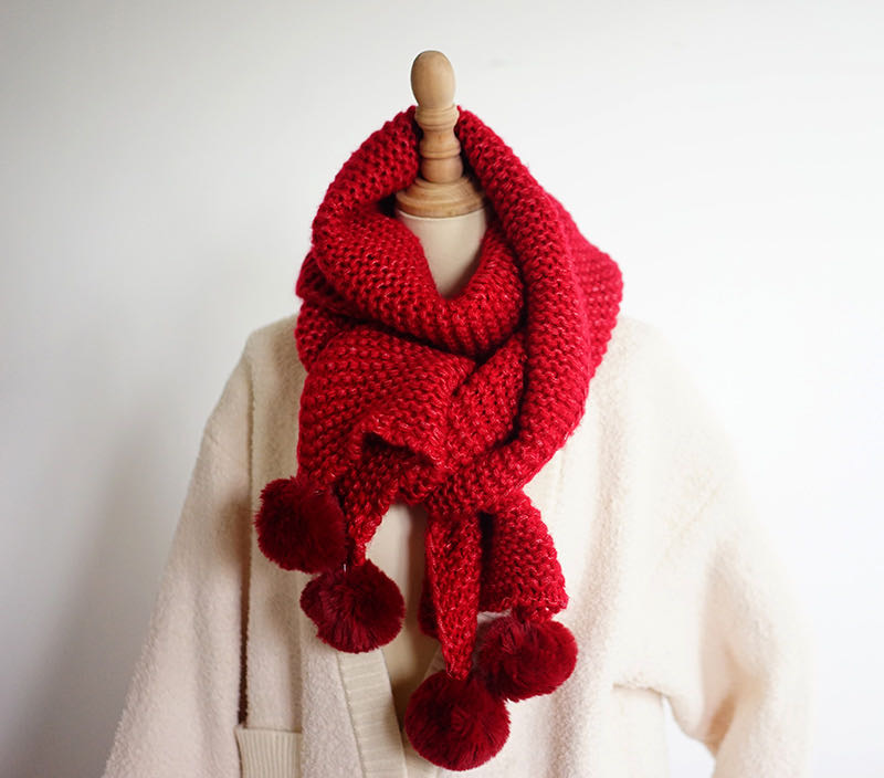 Close-up of thick red scarf texture showing dense knit pattern
