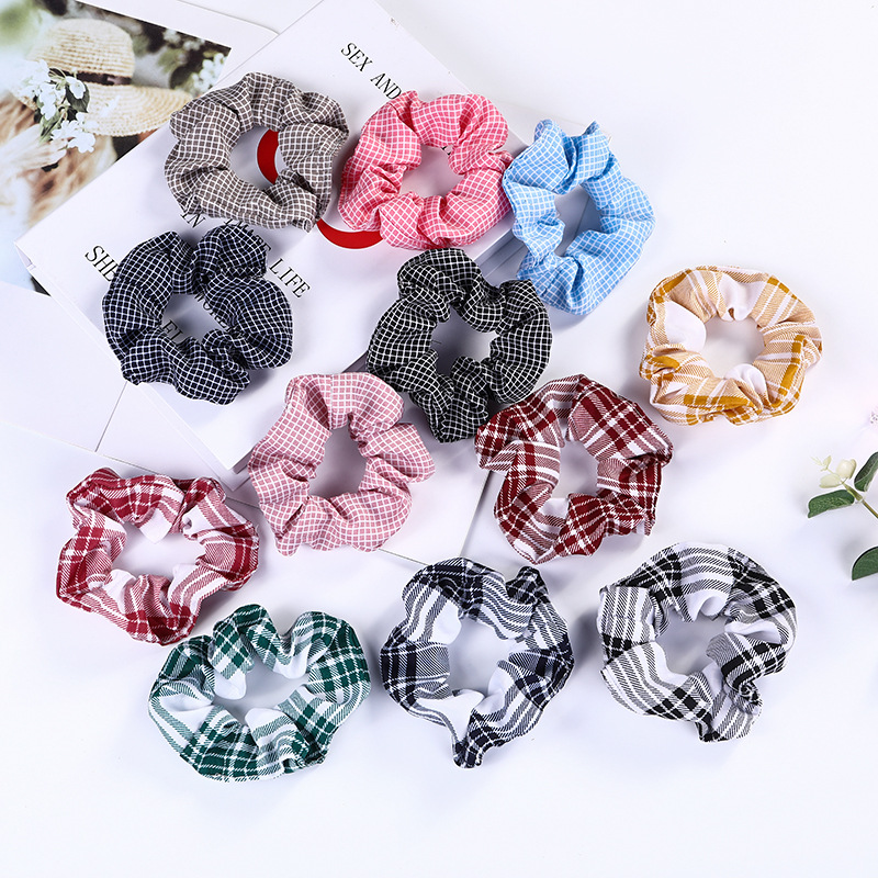 The checkered large intestine hair band is a popular series of headwear on campus. It is a fresh and elegant hair accessory for women. It is sold directly by Japanese and South Korean manufacturers. It is made of fabric hair ties