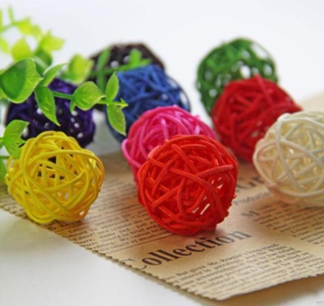 The natural-colored barnacle parrot bites the toy ball at the feet of the pet bird/foot grab/foot toy details Picture