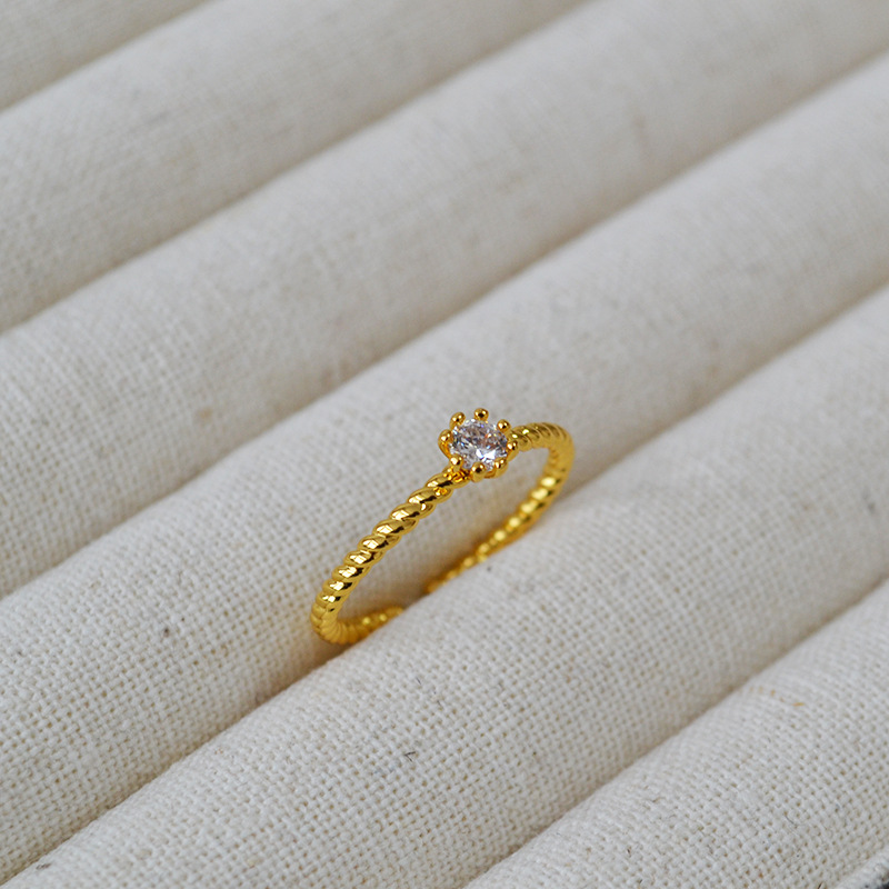 A small and simple Japanese and Korean brass gold-plated twist eight-prong ring with zircon flash diamonds and adjustable opening for the index finger ring