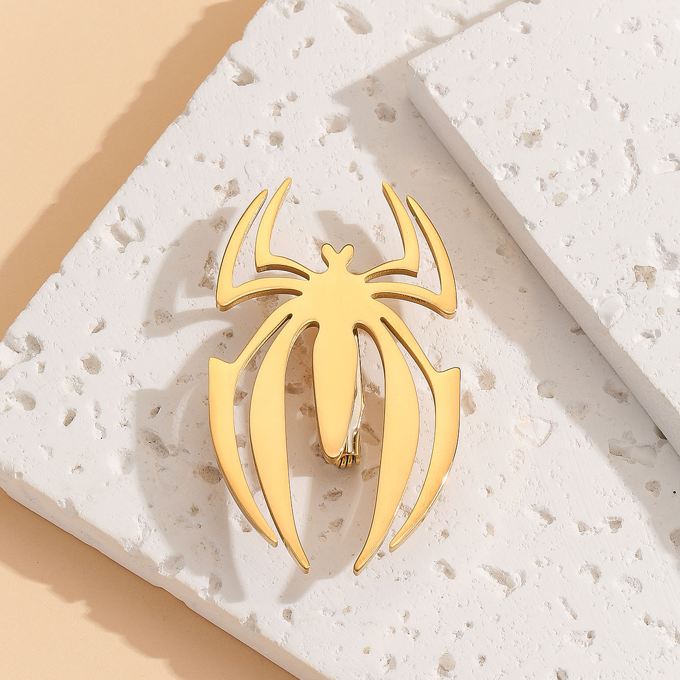 Cross-border simple and fashionable golden stainless steel smooth spider brooch, personalized and versatile pin anti-glare buckle wholesale Application Scenario