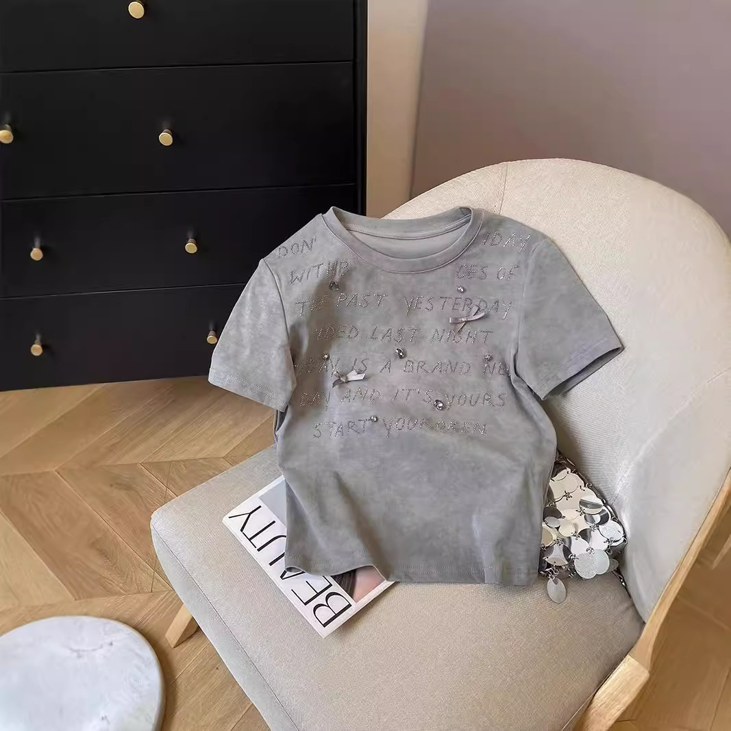 A unique short-sleeved T-shirt for women, a new summer style with a fitted shoulder and a Korean-style chic and high-end look, featuring a round neck and a straight shoulder