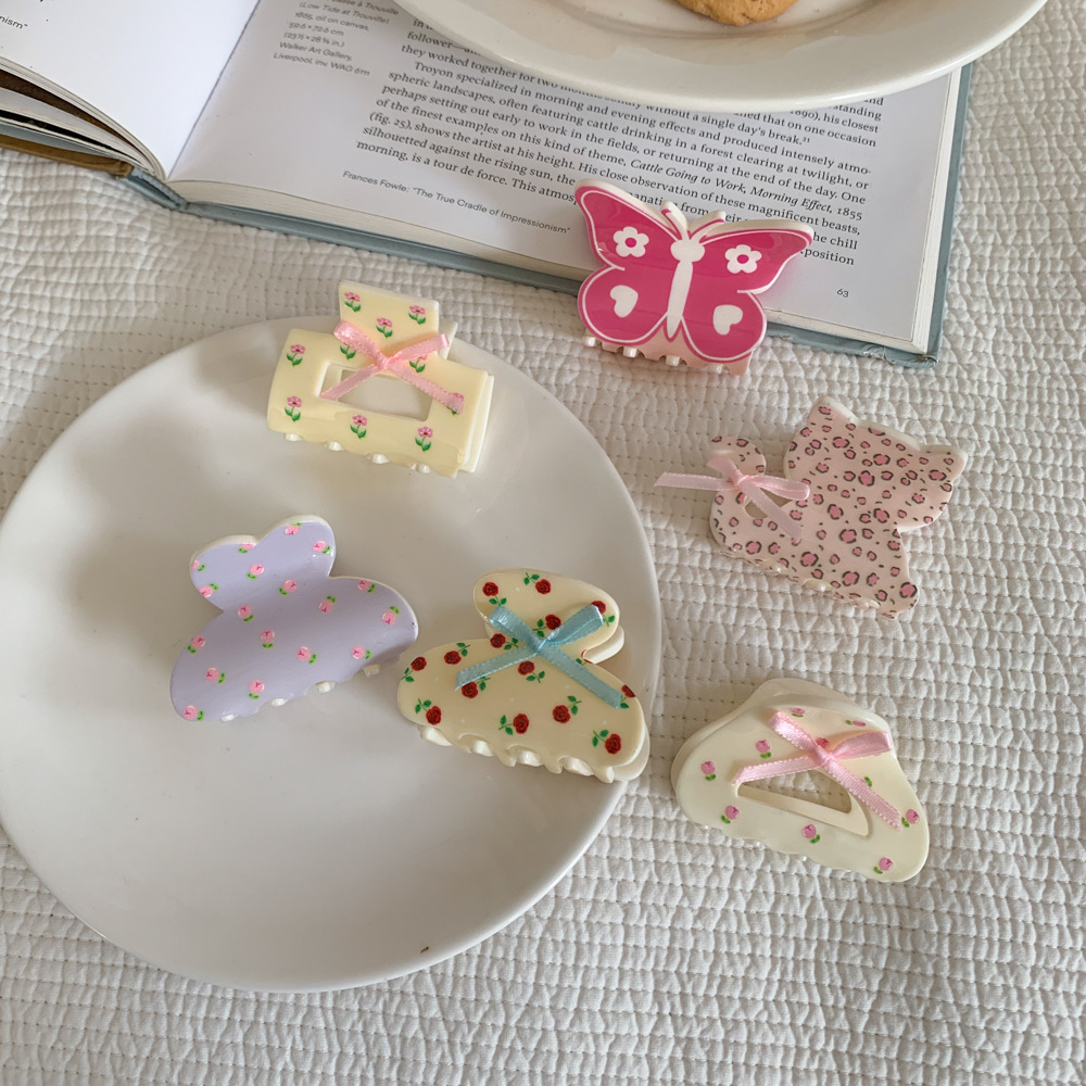 A cute girl with a small amount of hair, a small floral bow clip, a half-tied hair clip at the back of the head, and a shark clip with a high-end feel details Picture