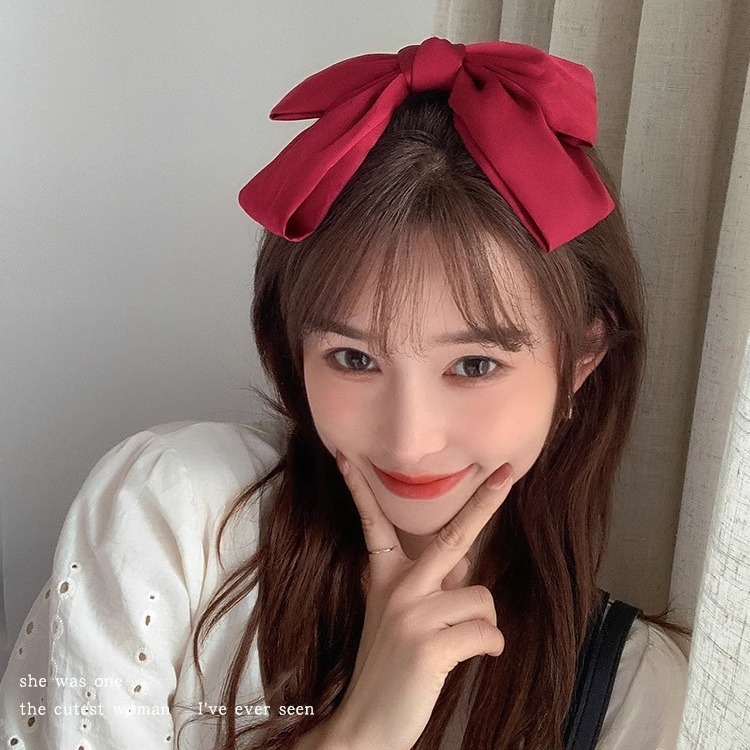 The trendy and versatile big bow hair tie at the back of a woman's head, with a hairpin loop and fabric hair accessory top clip Application Scenario