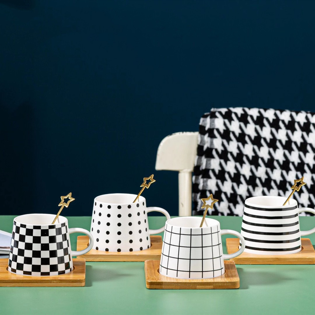 Couple black and white coffee cups, star spoons, ceramic cups with bamboo pads, mugs, Nordic line water cups, European style