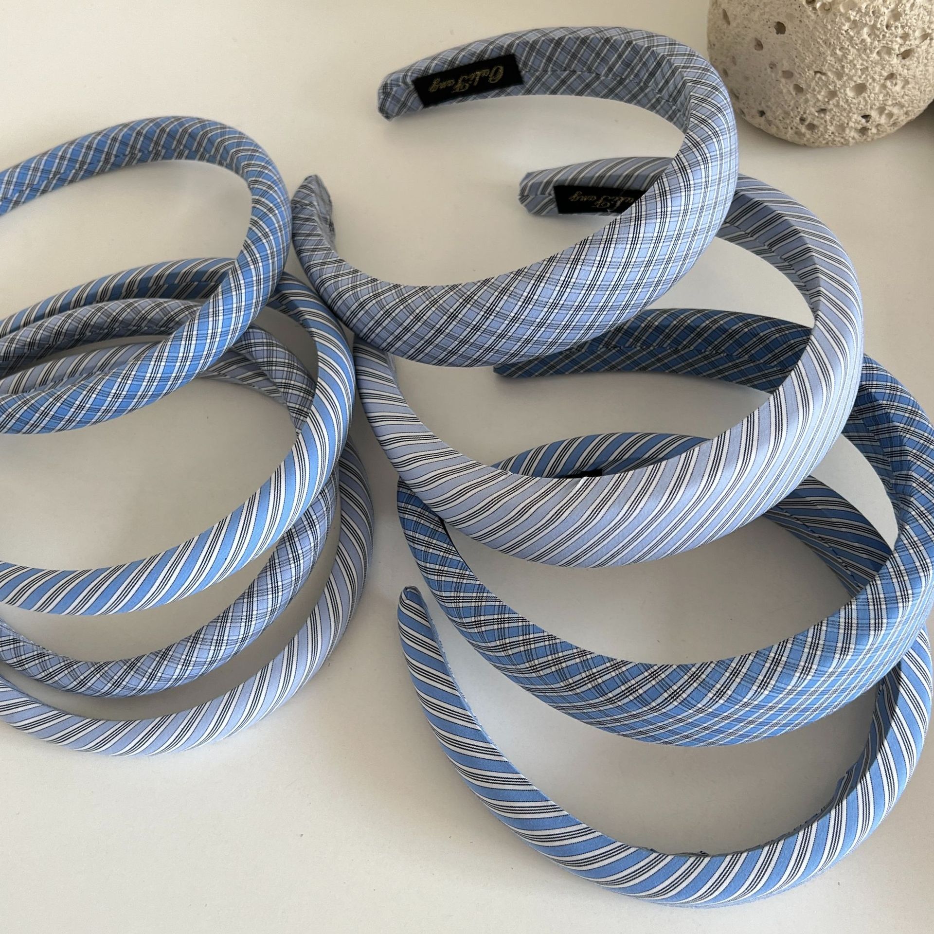 The blue checkered fabric sponge hairband from a Korean blogger is fashionable for going out. It is a versatile headband with a twill top pressure hairpin