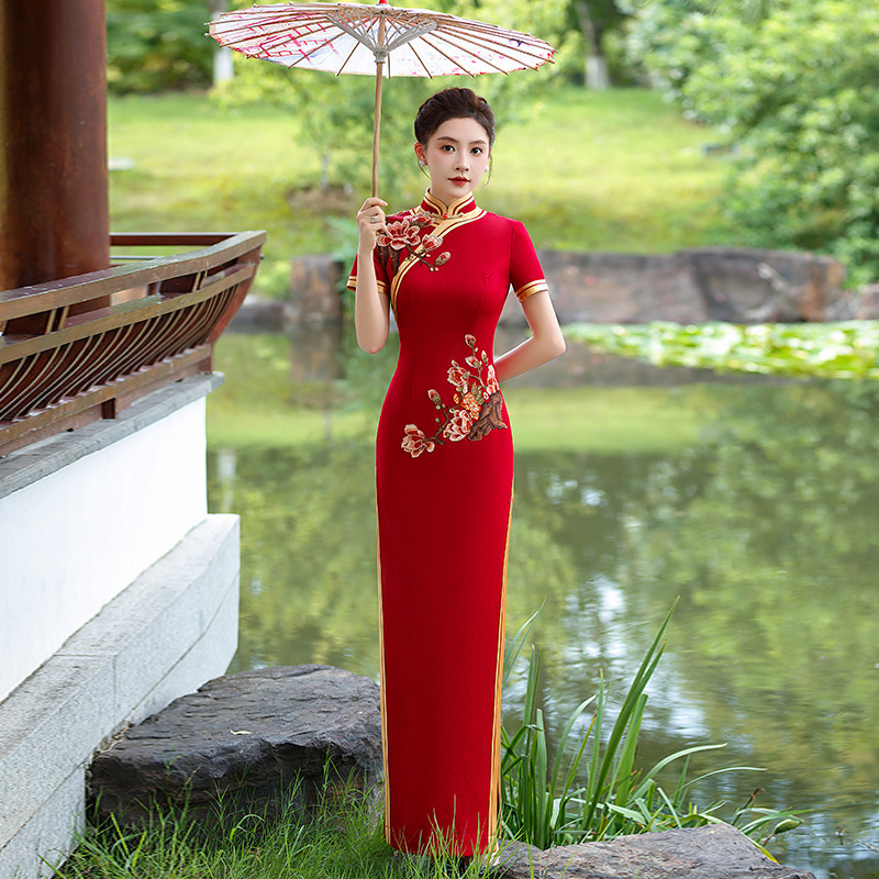 The new 2026 style of the improved cheongsam for young girls features a high slit and a retro Chinese style fashion show. The cheongsam is golden and fills the garden