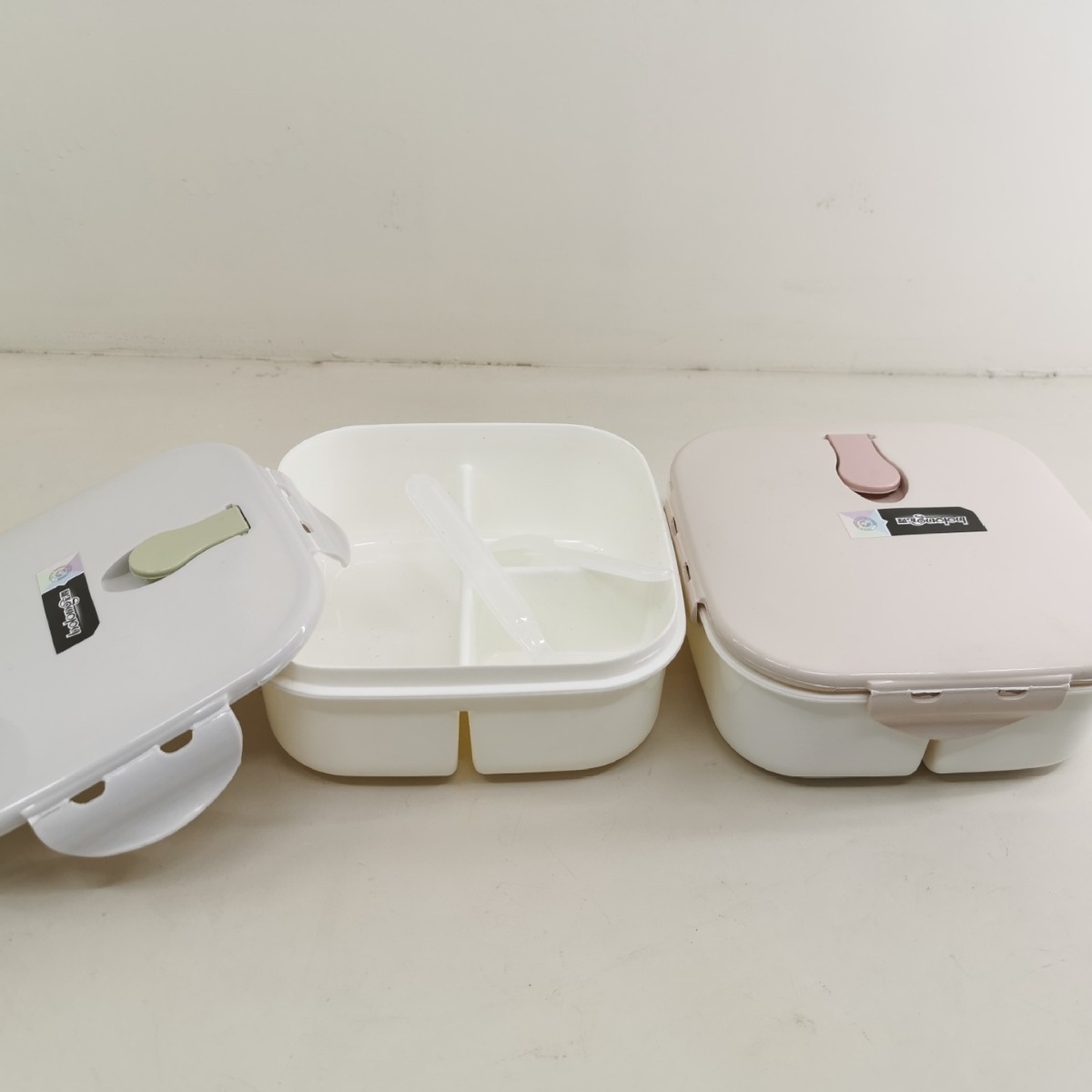 A square plastic lunch box with a spoon and fork that can be heated in a microwave oven, a student lunch box with three compartments, 1217 Item Picture