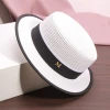 A white flat-topped straw hat with an M logo, a female summer outing sunshade beach hat, a model's catwalk performance, and a fashionable top hat details Picture