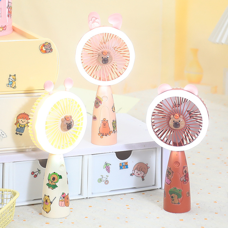 New three-speed strong wind power cartoon sticker handheld fan, student portable charging LED light desktop small fan