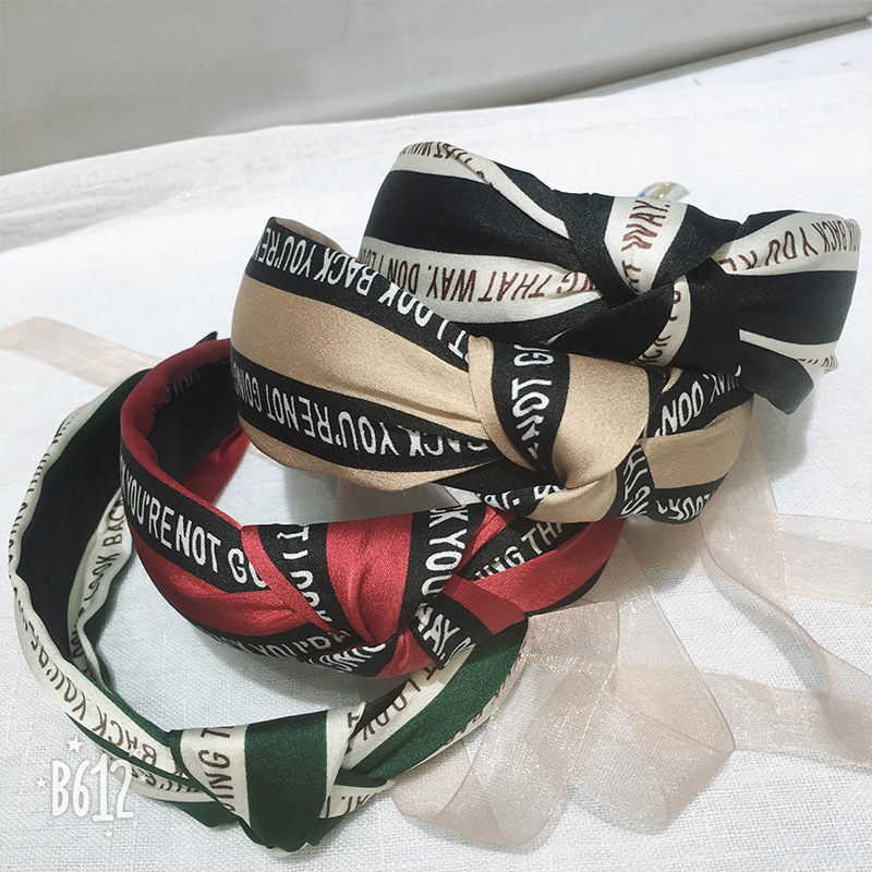 The knotted letter hair band is a popular Instagram hair band with wide edges and crossed fabric. It is a simple and fashionable adult hair accessory in Korean style