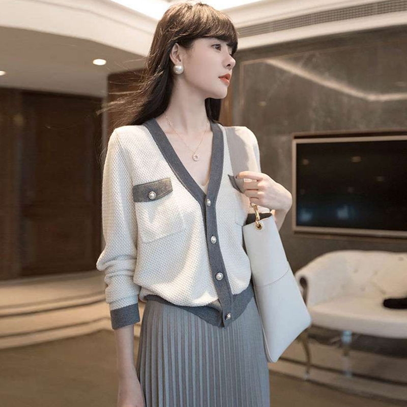 The new autumn women's wear features a retro and chic Hong Kong style, early autumn fashion with a chanel-style top. It has a V-neck and a contrasting color cardigan, exuding a touch of luxury