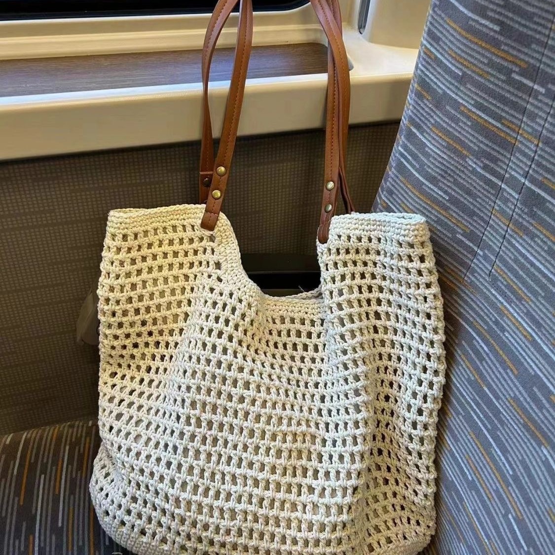 The 2025 new summer woven hollowed-out handbag made of cotton, the same style as the beach bag, is a niche design for women. It is a net bag bag for women