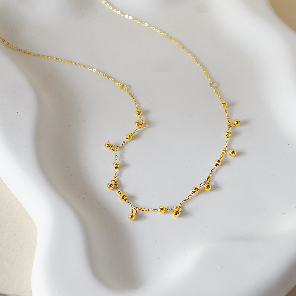 A popular 18K gold bean-shaped tassel necklace in Europe and America, featuring a minimalist and high-end look, is a versatile titanium steel collarbone necklace that goes well with a cold style on Instagram Application Scenario