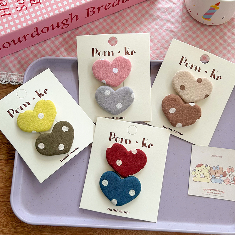 A new sweet and charming Korean-style fabric baby clip with heart-shaped dots that won't harm children's hair. A cute and versatile Korean-style hair accessory for young girls