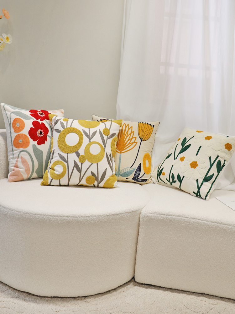 The living room features a simple sofa cushion, modern soft furnishings, a fresh and delicate embroidered throw pillow, and square all-cotton flower-shaped cushions details Picture