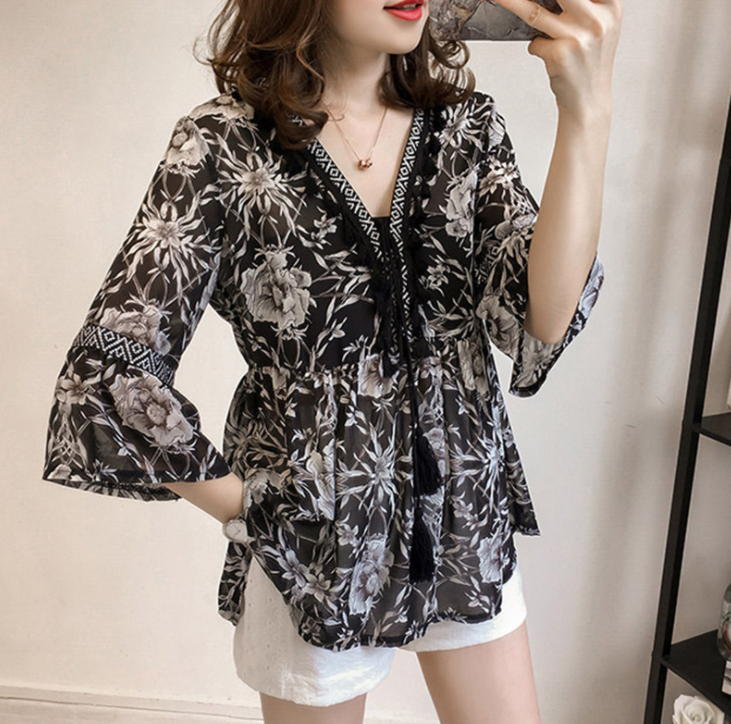 A loose floral chiffon shirt that covers the belly and cinches the waist, exuding an ethereal charm. It is a V-neck top with three-quarter sleeves details Picture